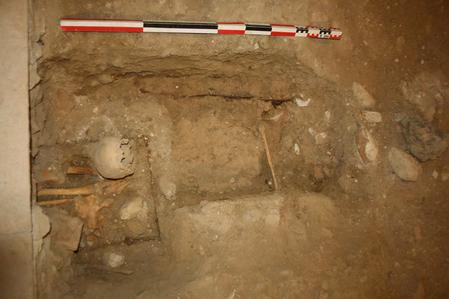 Inhumation primaire avec crne en rduction et traces de cercueils.