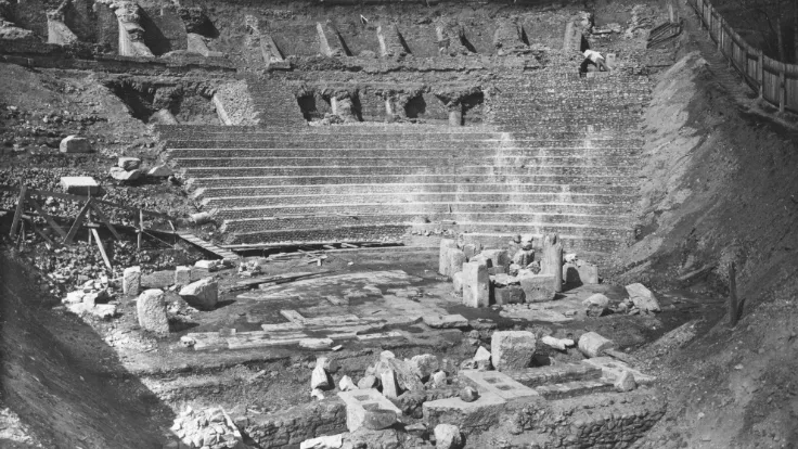 Photo en noir et blanc représentant les gradins du théâtre antique de Fourvière lors de leur mise au jour. Les vestiges sont en ruines et les gradins ne sont pas encore totalement dégagés..